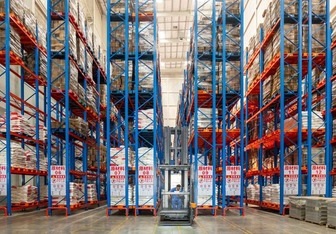 I carrelli elevatori a torretta VNA Man-Up consentono uno stoccaggio ad alta densità di 13 m per un produttore leader di condimenti